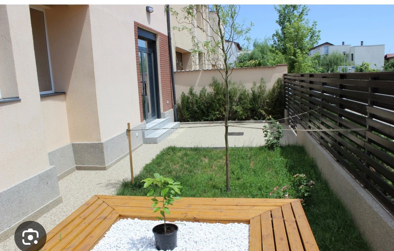 Curtea cu iarbă, bănci de lemn și verdeață a centrului After School Georgi